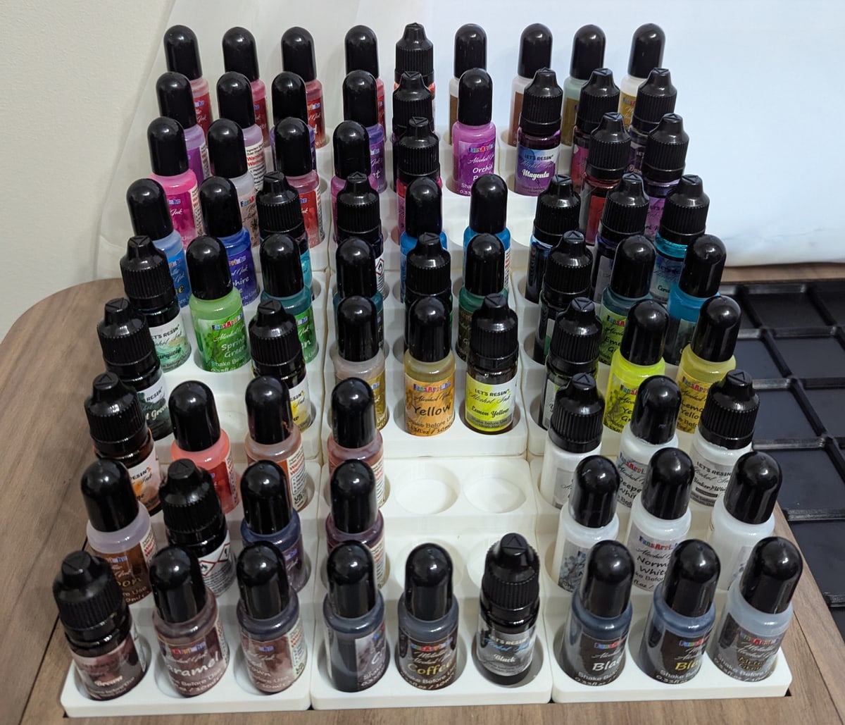 Racks of resin pigment bottles in the Kaidora Art studio